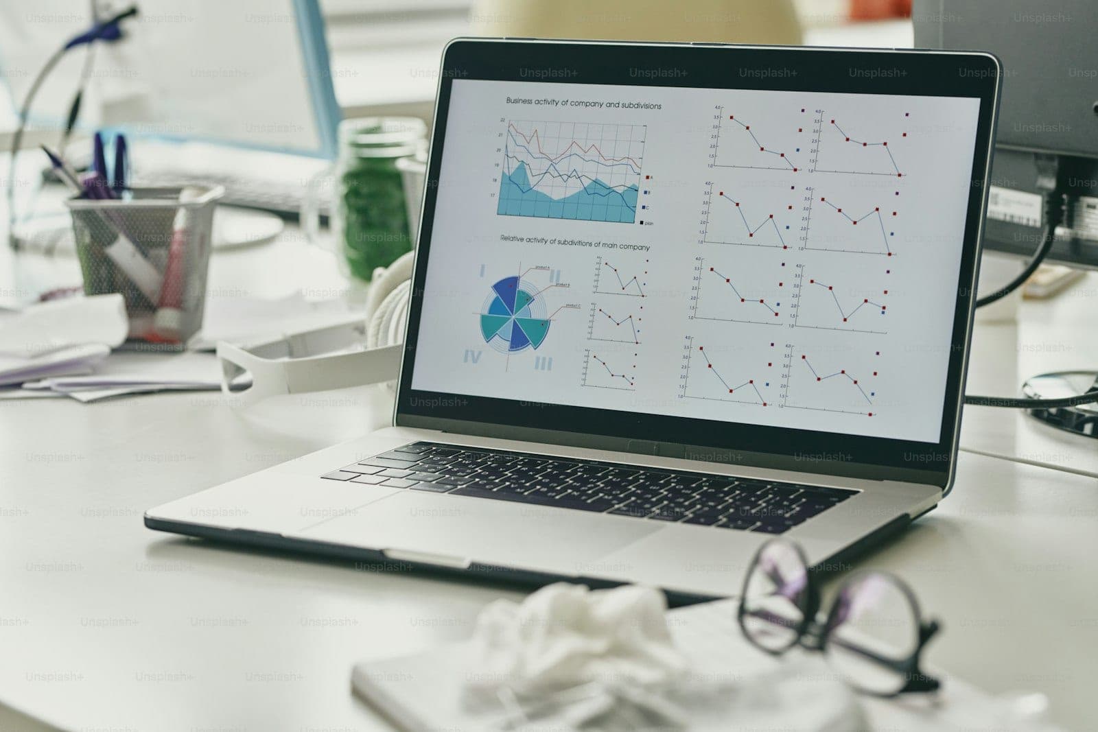 A laptop displaying a multi-panel analytics report of line and pie charts