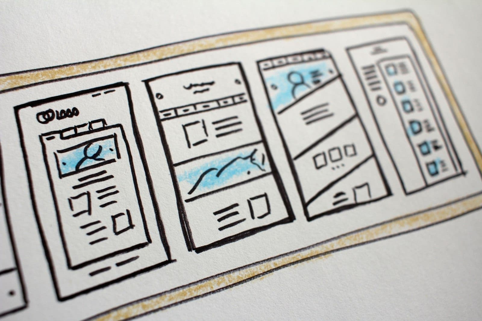 Hand-drawn mobile interface wireframes sketched across a sheet of paper